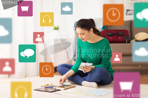 Image of happy woman with money and travel map at home