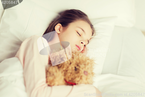 Image of girl sleeping with teddy bear toy in bed at home