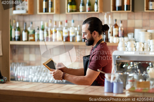 Image of happy man or waiter with chalkboard banner at bar