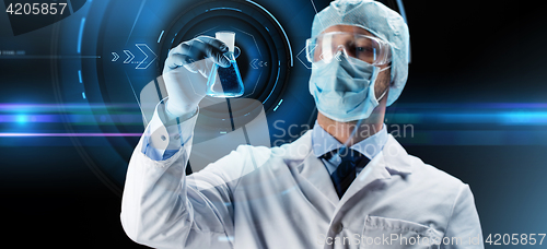 Image of scientist in mask holding flask with chemical