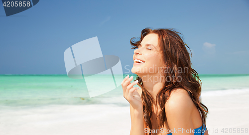 Image of happy smiling young woman on tropical beach