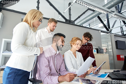 Image of business team with tablet pc and papers at office