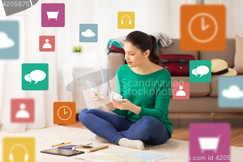 Image of happy woman with money and travel map at home