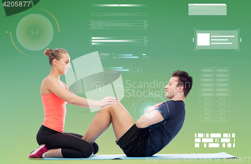 Image of happy sportive man and woman doing sit-ups