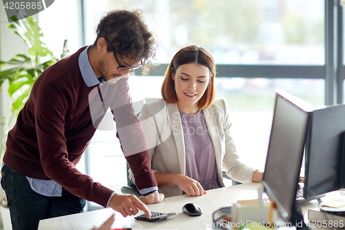 Image of happy business team with calculator at office