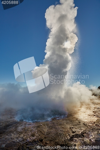 Image of Erupting geyser in sunlight