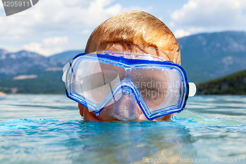 Image of Boy with scuba mask in a lake 