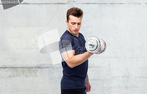 Image of sportive man flexing muscles with dumbbell