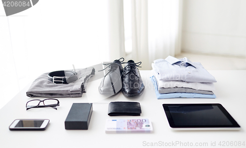 Image of clothes, gadgets and business stuff on table