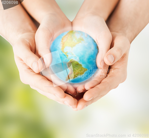 Image of woman and man hands holding earth planet