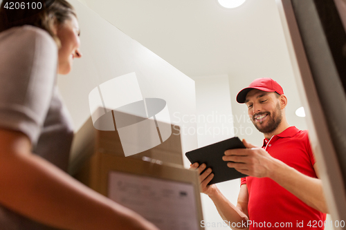 Image of deliveryman with tablet pc and customer with boxes