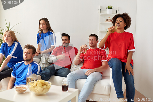 Image of friends or football fans watching soccer at home