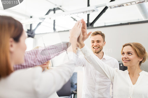 Image of happy business team making high five at office