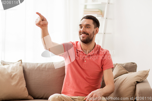 Image of happy man touching something imaginary at home