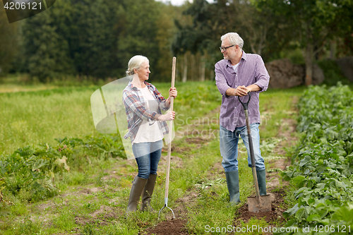 Image of senior couple with shovels at garden or farm