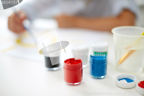 Image of little girl painting with gouache colors