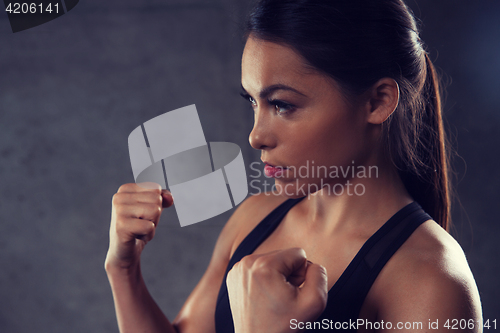 Image of woman holding fists and fighting in gym