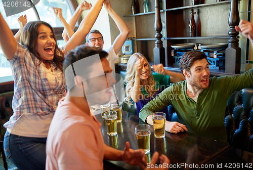 Image of football fans or friends with beer at sport bar