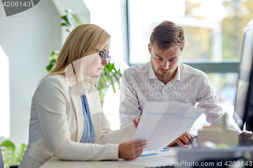 Image of business team discussing papers at office table