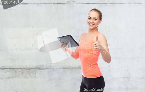 Image of happy smiling sportive young woman with tablet pc