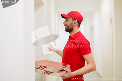 Image of delivery man with pizza boxes ringing doorbell