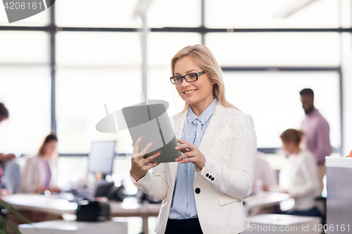 Image of smiling businesswoman with tablet pc at office