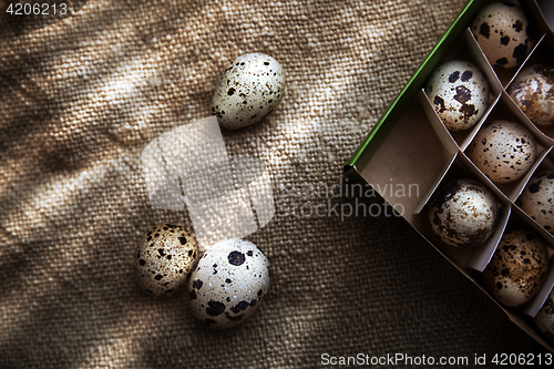 Image of Quail eggs in carton box on a sackcloth