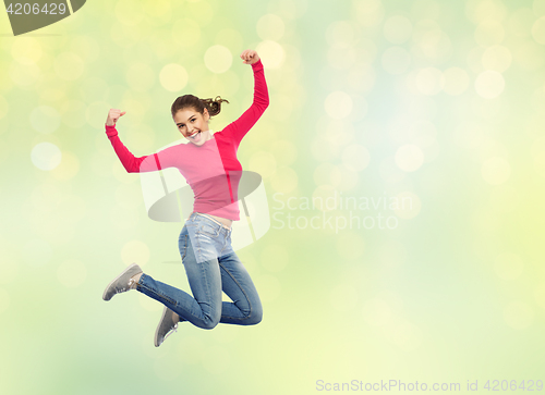 Image of smiling young woman jumping in air