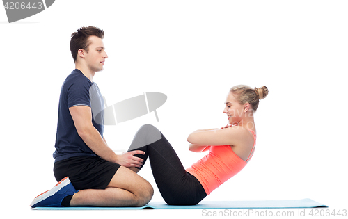 Image of happy sportive man and woman doing sit-ups