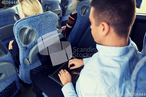 Image of man with smartphone and laptop in travel bus
