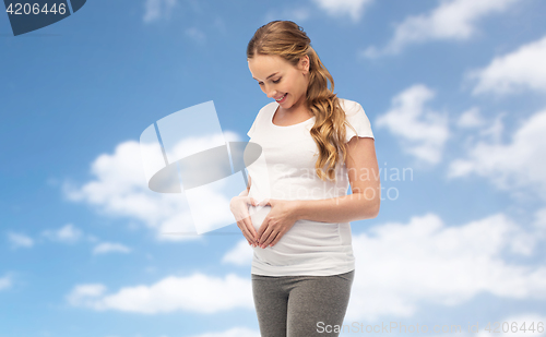 Image of happy pregnant woman showing heart gesture