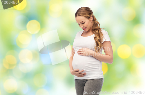 Image of happy pregnant woman touching her big belly