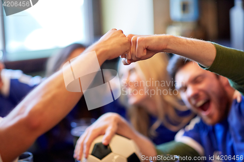 Image of soccer fans with ball celebrating victory at bar