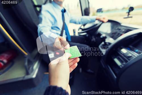 Image of bus driver taking ticket or card from passenger