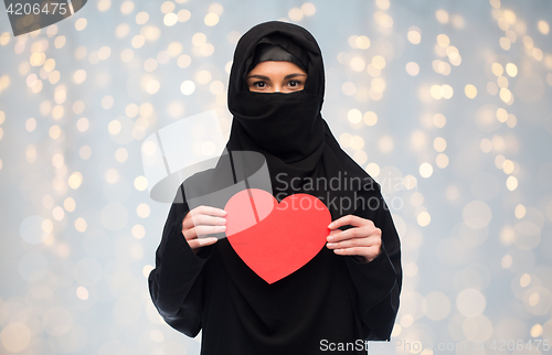 Image of muslim woman in hijab holding red heart