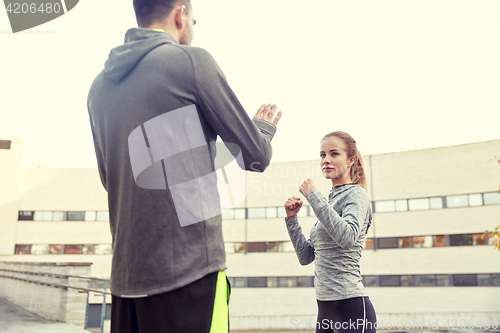 Image of woman with trainer working out self defense strike