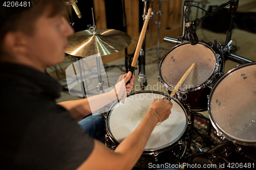 Image of male musician playing drums and cymbals at concert