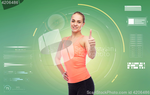 Image of happy sportive young woman showing thumbs up