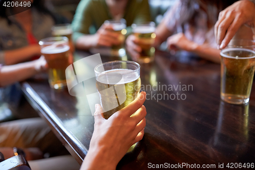 Image of friends drinking beer at bar or pub