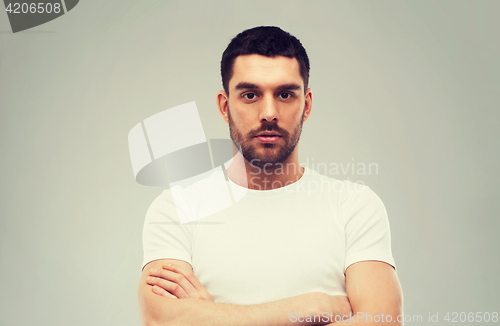 Image of young man with crossed arms over gray background