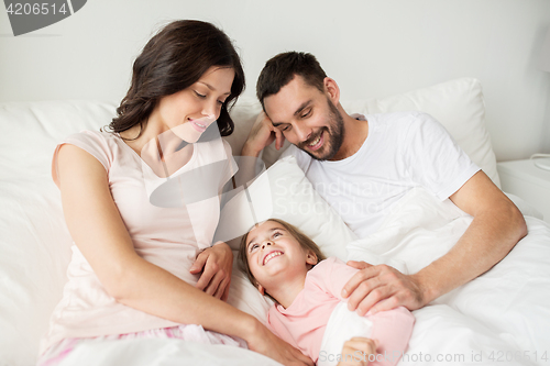 Image of happy family in bed at home