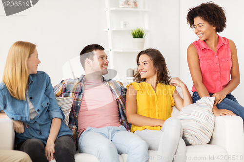 Image of group of happy friends talking at home