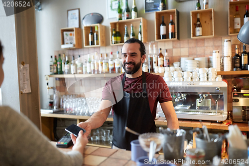 Image of barman and woman with card reader and smartphone