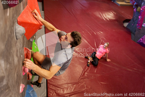 Image of man and woman exercising at indoor climbing gym