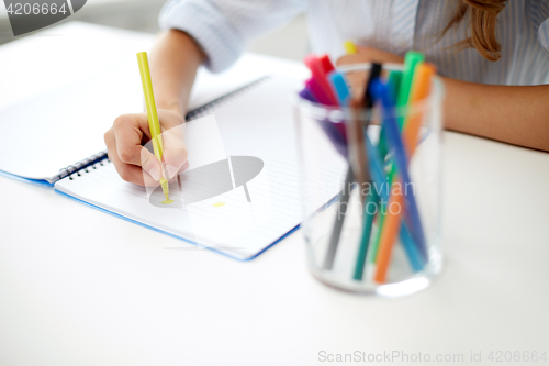 Image of girl drawing with felt-tip pen in notebook