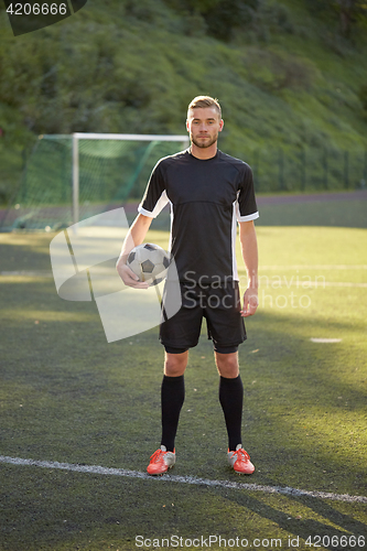 Image of soccer player with ball on football field