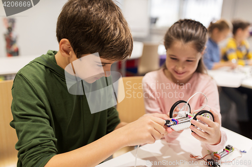 Image of happy children building robots at robotics school