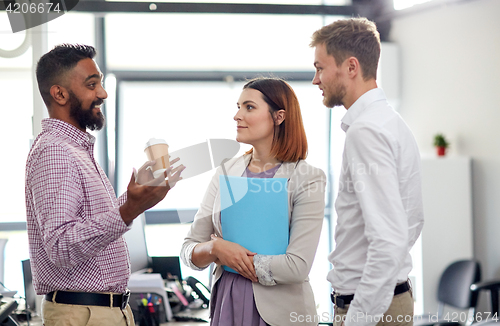 Image of happy business team drinking coffee at office