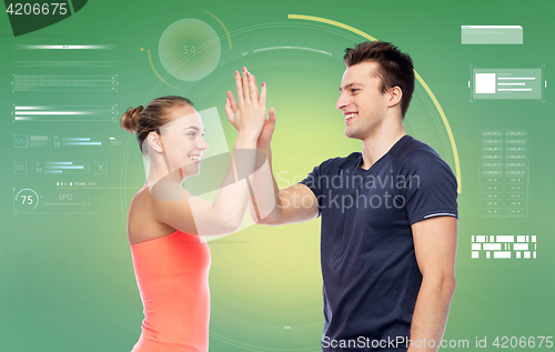 Image of happy sportive man and woman making high five