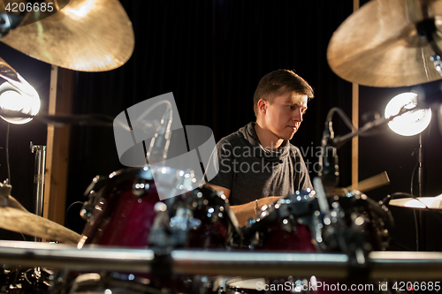 Image of male musician playing drums and cymbals at concert